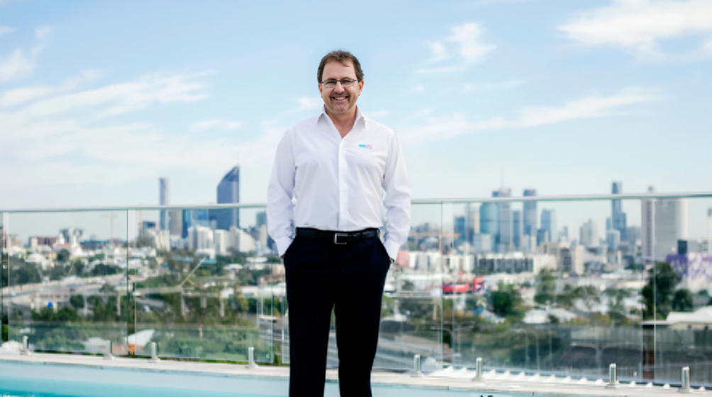 John O'Brien, founder and CEO of Poolwerx, stands proudly in front of a Poolwerx service vehicle, symbolizing his leadership and innovation in the pool maintenance and franchising industry.