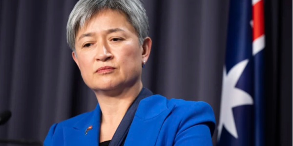 Penny Wong, an influential Australian politician and Minister for Foreign Affairs, speaks at a podium, exuding confidence and determination.