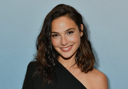 A headshot of Gal Gadot, showcasing her elegant features and confident smile, with a soft-focus background highlighting her charisma.