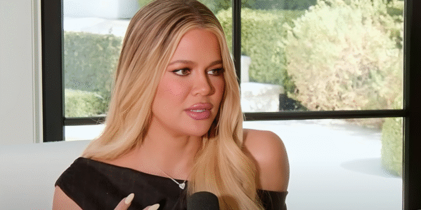 Khloé Kardashian smiling in a stylish outfit, promoting her fashion brand Good American.