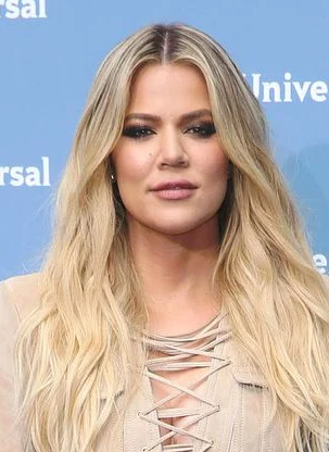Khloé Kardashian smiling in a stylish outfit, promoting her fashion brand Good American.